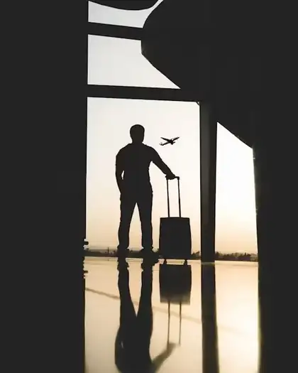 Traveller with luggage watching a plane at an airport